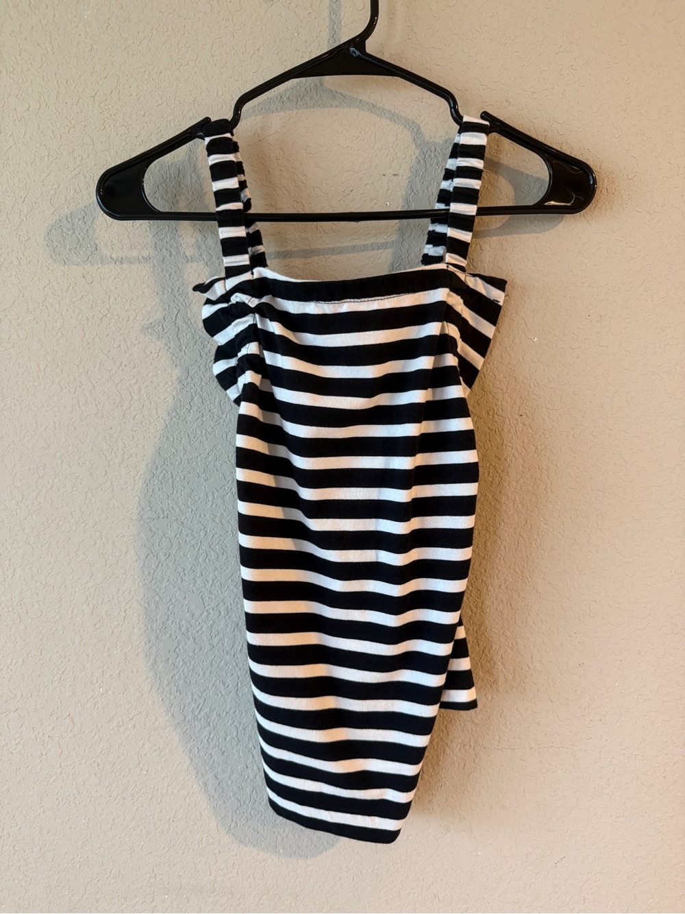 Striped crossed back tank with flared neckline.
